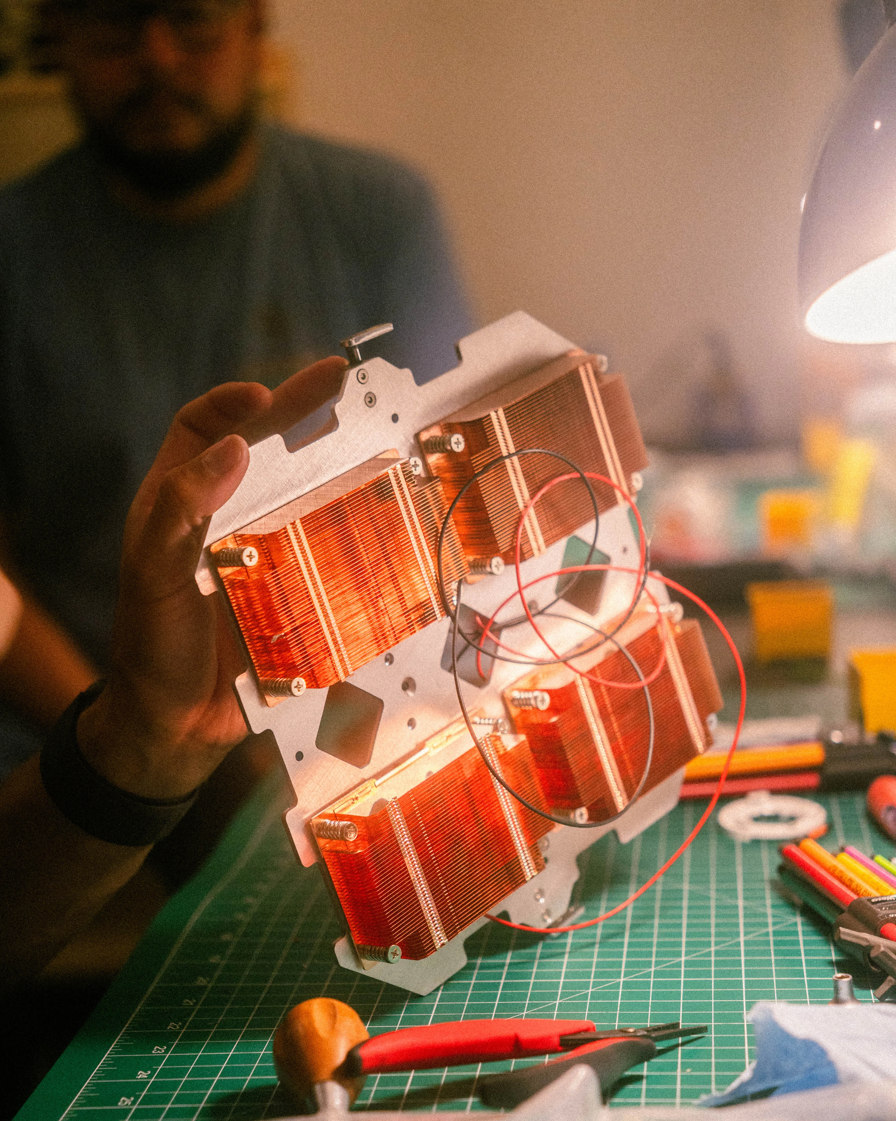 A light engine held up to the bench lamp, lit red from within