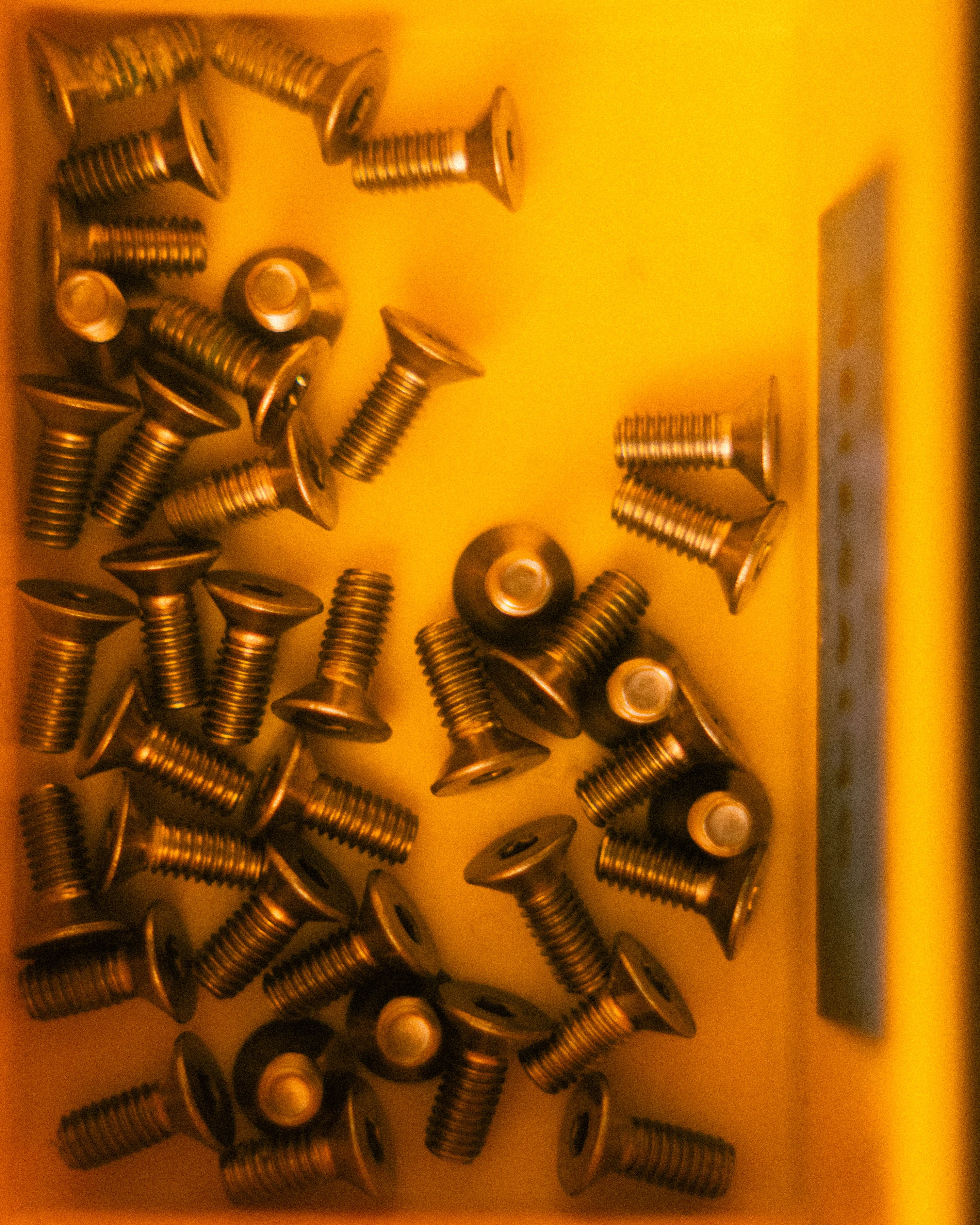 A scatter of brass machine screws on the assembly bench