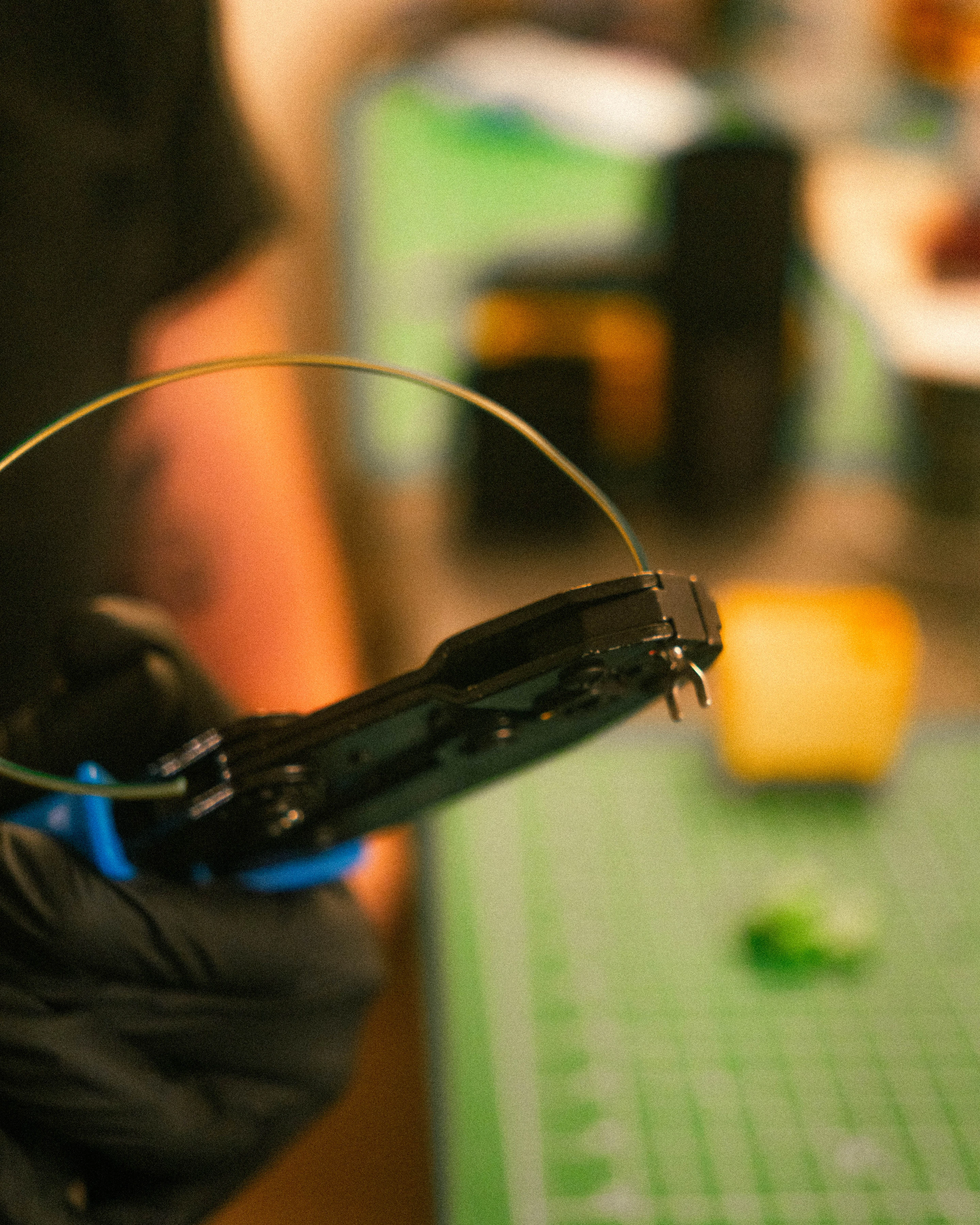 A gloved hand drawing wiring through a housing